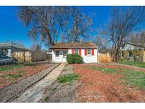 Cute bungalow with red trim, landscaped yard, and wood fence at 1565 Xanthia St, Denver, CO 80220