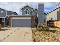 Two-story house with gray siding, attached garage, and a small front yard at 6253 Xavier St, Arvada, CO 80003