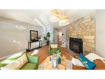 Spacious living room with stone fireplace and hardwood floors at 1811 S Quebec Way # 220, Denver, CO 80231