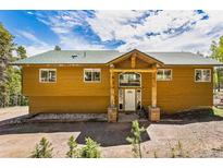 Mountain home with wood siding and large covered entryway at 8 Yuma Trl, Evergreen, CO 80439