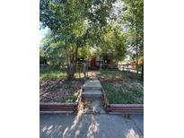 Home exterior featuring a walkway leading to the front door and a landscaped yard at 2080 Emporia St, Aurora, CO 80010