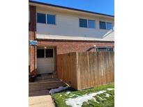 Exterior view of a townhouse with a wooden fence and small deck at 8031 Wolff St # H, Westminster, CO 80031