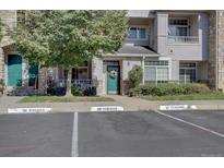 Townhouse exterior with green door, landscaping, and reserved parking spaces at 9448 E Florida Ave # 1078, Denver, CO 80247