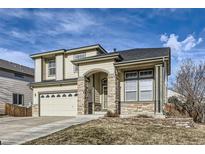 Two-story house with a neutral color scheme and stone accents at 12946 Kearney St, Thornton, CO 80602