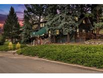 Exterior of charming lodge-style home nestled in a wooded area at 27425 Spruce Ln, Evergreen, CO 80439