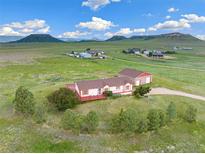 Aerial view of a ranch-style home with detached garage and expansive land at 12155 Mesa View Rd, Larkspur, CO 80118