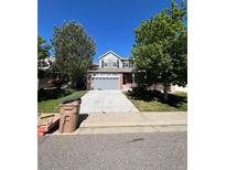 Two-story home with gray siding, brick accents, and a two-car garage at 6043 S Waco St, Aurora, CO 80016