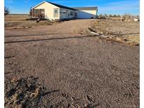 Ranch style home with gravel driveway and spacious yard at 41321 E 88Th Ave, Bennett, CO 80102