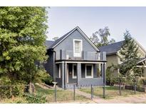 Gray two-story house with a balcony, small front yard, and black fence at 2731 California St, Denver, CO 80205