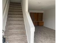 Image shows a carpeted staircase leading to an upper level with built-in shelving at 912 S Peoria St, Aurora, CO 80012