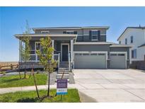 Two-story house with gray siding, a three-car garage, and a landscaped front yard at 3352 N Highlands Creek Pkwy, Aurora, CO 80019