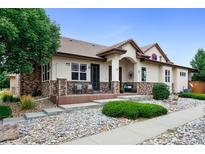 House exterior with stone accents, a covered porch, and well-maintained landscaping at 11422 Chambers Dr, Commerce City, CO 80022