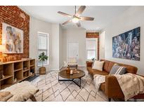 Bright living room with exposed brick, modern furnishings, and a cozy atmosphere at 1516 Lafayette St, Denver, CO 80218
