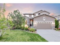 Two-story house with attached garage and landscaped front yard at 11785 W Rowland Ave, Littleton, CO 80127