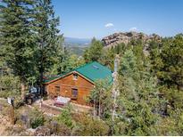 Secluded mountain cabin with a green roof, nestled in the trees at 80 Outlook Dr, Golden, CO 80403