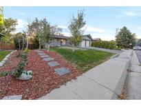 Landscaped front yard with walkway to the house at 3955 S Uinta St, Denver, CO 80237