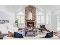 Living room with a brick fireplace and large windows at 10182 Stoneridge Ter, Parker, CO 80134