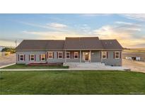 Ranch-style home with green exterior and landscaping at 59304 E Commanche Way, Strasburg, CO 80136