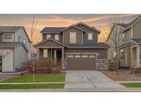 Two-story house with gray siding, brown accents, and a two-car garage at 12897 Creekwood St, Firestone, CO 80504