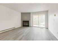 Bright living room with fireplace and sliding door access to balcony at 14740 E Kentucky Dr # 736, Aurora, CO 80012