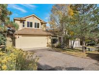 Two-story house with beige siding, attached garage, and landscaping at 24087 Deer Valley Rd, Golden, CO 80401