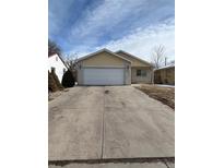 Ranch style home with a two-car garage and landscaped yard at 894 S Krameria St, Denver, CO 80224