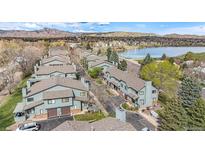 Aerial view of townhouses near a lake with mountain views in the background at 10330 W Jewell Ave # A, Lakewood, CO 80232