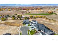 Aerial view of houses with mountain views in the background at 1591 Mariah Ln, Erie, CO 80516