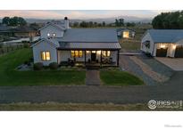 Stunning aerial view of a farmhouse with detached garage and expansive property at 560 Talons Reach Run, Berthoud, CO 80513