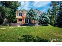 House with a large backyard, pergola, and landscaping at 4663 Quail Creek Ln, Boulder, CO 80301