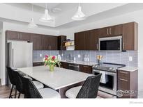 Modern kitchen with island, stainless steel appliances and dark cabinetry at 1707 Walnut St # 105, Boulder, CO 80302