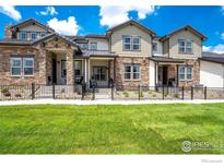 Two-story townhome with stone and siding exterior at 1481 Harebell St, Berthoud, CO 80513