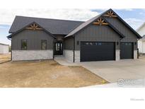 Craftsman style home with gray siding, stone accents, and a two-car garage at 1271 Burt Ave, Berthoud, CO 80513