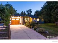 Mid-century modern home with a wooden garage door and landscaped yard at night at 1600 Alpine Ave, Boulder, CO 80304