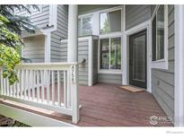 Inviting front porch with wooden deck and white railing at 4758 Franklin Dr, Boulder, CO 80301