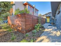 Landscaped front yard with modern wood fence and walkway at 3877 Utica St, Denver, CO 80212