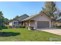 Tan house with green roof and two-car garage at 215 1St St, Mead, CO 80542