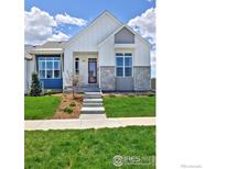 Two-story craftsman style home with gray and white exterior, landscaping, and a red door at 751 W Grange Ct # B, Longmont, CO 80503