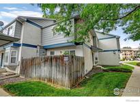 Two-story townhome with gray siding and private fenced yard at 2213 Emery St # C, Longmont, CO 80501