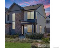 Two-story home with gray and white siding, stone accents, and a charming front porch at 9284 Gore St # D, Arvada, CO 80007