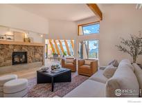 Spacious living room with stone fireplace and ample natural light at 225 Bristlecone Way, Boulder, CO 80304