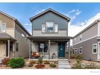 Front view of a charming two-story house with a welcoming porch and landscaping at 1135 Hummingbird Cir, Longmont, CO 80501