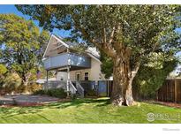 Charming two-story home with a large tree in front and a spacious lawn at 1110 Hover St, Longmont, CO 80501