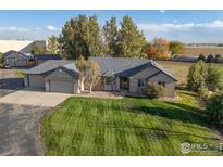 Ranch-style home with a large yard and detached garage at 8002 Sunrise Cir, Frederick, CO 80516