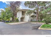 Exterior view of a two story light colored apartment building at 2707 Valmont Rd # 110B, Boulder, CO 80304