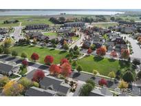 Aerial view of a neighborhood with a large park and fall foliage at 1463 Moonlight Dr, Longmont, CO 80504