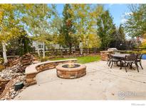 Spacious backyard with fire pit, built-in BBQ, and seating area at 1138 Lasnik St, Erie, CO 80516