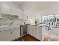 Bright kitchen with white cabinets, granite counters, and stainless steel appliances at 1850 Folsom St # 204, Boulder, CO 80302