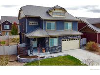 Two-story house with a backyard patio, surrounded by other houses at 185 Pipit Lake Way, Erie, CO 80516