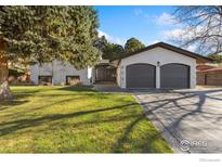 White house with dark gray garage doors and a manicured lawn at 612 S Bermont Ave, Lafayette, CO 80026